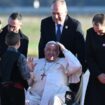 Le pape François est accueilli par le ministre de l'Intérieur Bruno Retailleau (g) et des enfants à son arrivée l'aéroport d'Ajaccio, le 15 décembre 2024