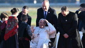 Le pape François est accueilli par le ministre de l'Intérieur Bruno Retailleau (g) et des enfants à son arrivée l'aéroport d'Ajaccio, le 15 décembre 2024