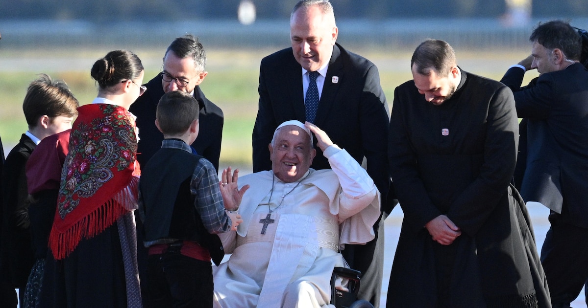 Le pape François est accueilli par le ministre de l'Intérieur Bruno Retailleau (g) et des enfants à son arrivée l'aéroport d'Ajaccio, le 15 décembre 2024