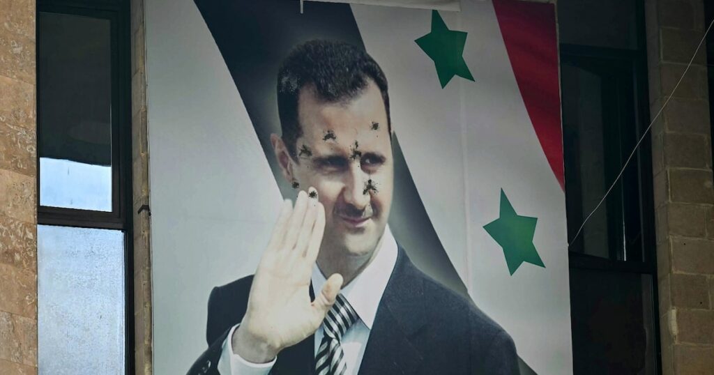 Un poster du président syrien déchu Bachar al-Assad criblé de balles, le 12 dcéembre 2024 à Alep, dans le nord de la Syrie