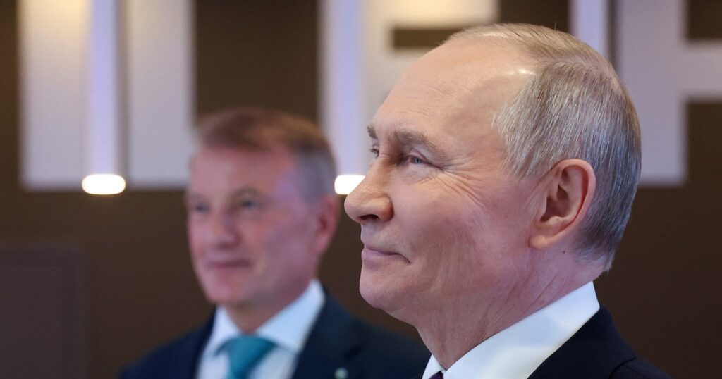 Sur cette photo de pool diffusée par l'agence d'État russe Sputnik, le président russe Vladimir Poutine (à droite) et le PDG de la Sberbank russe, German Gref, regardent une exposition sur les développements dans le domaine de l'intelligence artificielle lors de la conférence de la Sberbank sur l'intelligence artificielle à Moscou le 11 décembre 2024.