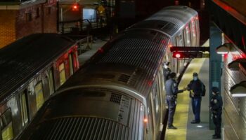 FILE - New York Police officers clear a train at the Coney Island Stillwell Avenue Terminal, May 5, 2020, in the Brooklyn borough of New York. (AP Photo/Frank Franklin II, file)