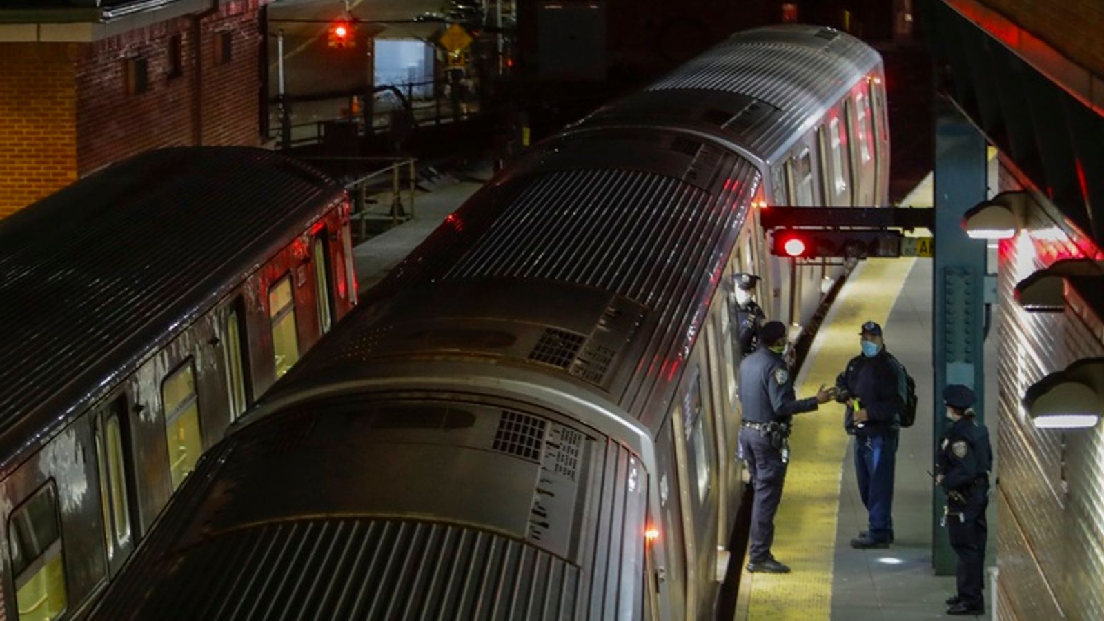 FILE - New York Police officers clear a train at the Coney Island Stillwell Avenue Terminal, May 5, 2020, in the Brooklyn borough of New York. (AP Photo/Frank Franklin II, file)