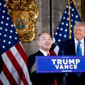 PALM BEACH, FLORIDA - DECEMBER 16: SoftBank CEO Masayoshi Son (C), accompanied by U.S. President-elect Donald Trump (R) and Trump's choice for Secretary of Commerce, Cantor Fitzgerald Chairman and CEO Howard Lutnick (L), speaks at a news conference at Trump's Mar-a-Lago resort on December 16, 2024 in Palm Beach, Florida. In a news conference that went over an hour, Trump announced that SoftBank will invest over $100 billion in projects in the United States including 100,000 artificial intelligence related jobs and then took questions on Syria, Israel, Ukraine, the economy, cabinet picks, and many other topics.   Andrew Harnik/Getty Images/AFP (Photo by Andrew Harnik / GETTY IMAGES NORTH AMERICA / Getty Images via AFP)