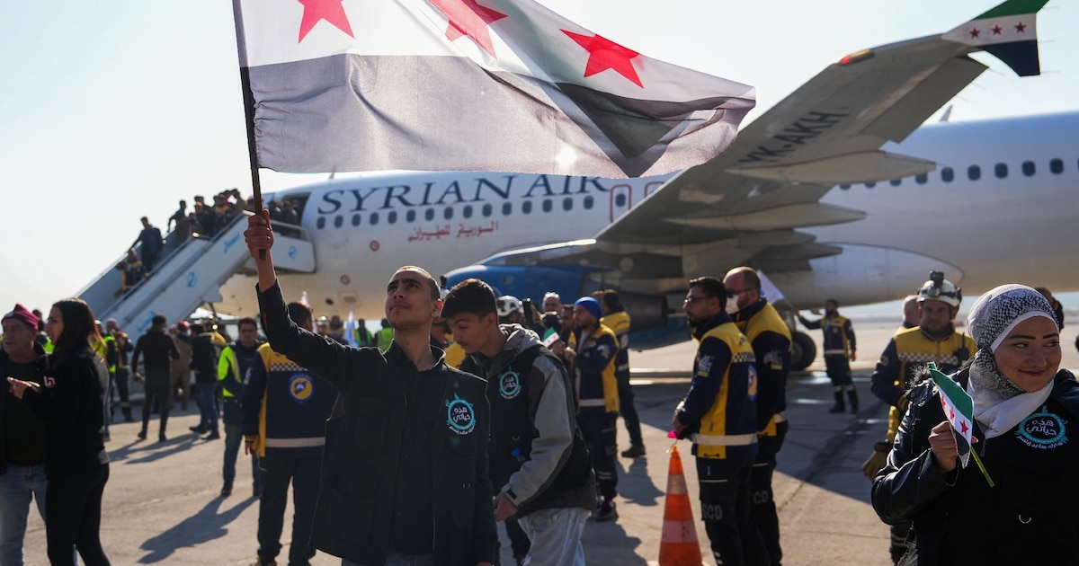 Des passager descendent d'un avion en provenance de Damas, le premier depuis la chute de Bachar al-Assad, à leur arrivée à l'aéroport d'Alep, le 18 décembre 2024 en Syrie