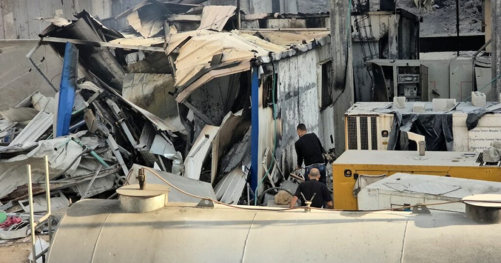 Deux hommes inspectent des dégâts causés par des frappes israéliens à l'extérieur de l'hôpital Kamal Adwan, dans le nord de la bande de Gaza, le 6 décembre 2024