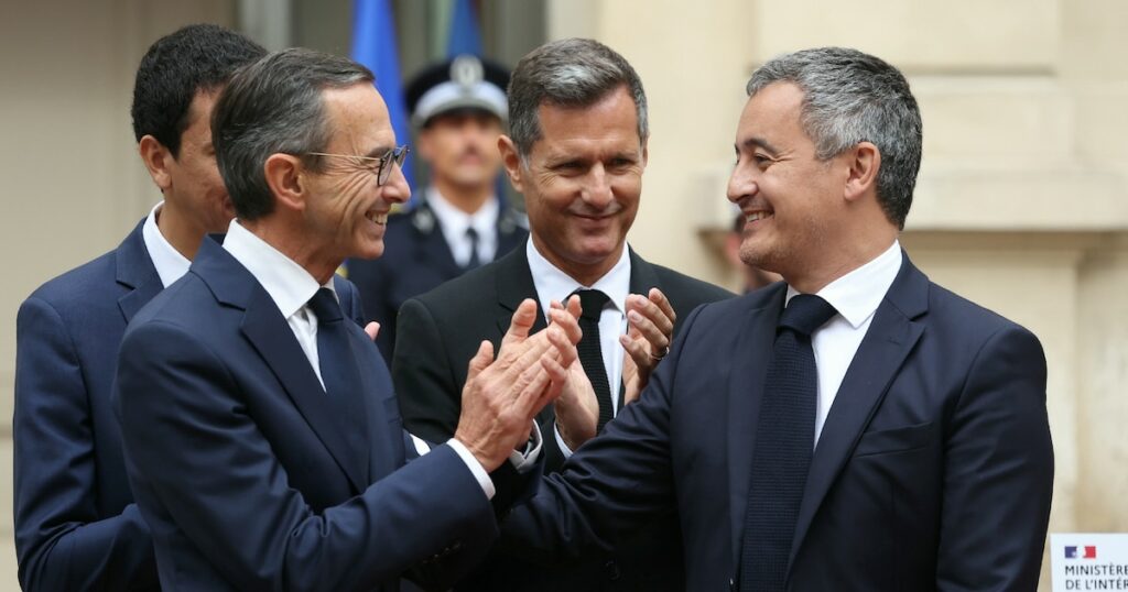 Le nouveau ministre de l'Intérieur Bruno Retailleau (gauche) applaudit Gérald Darmanin lors de la passation de pouvoir à l'hôtel de Beauvau le 23 septembre 2024 à Paris