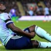 Arsenal's Bukayo Saka holds the back of his leg as he sits on the field after suffering an injury against Crystal Palace