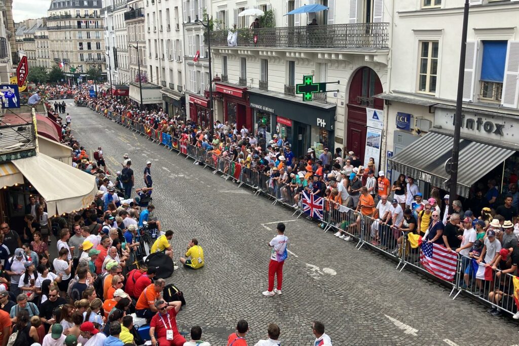 Depuis un balcon, une vue plongeante sur la rue Lepic et les coureurs