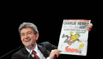 Le candidat du Front de Gauche (FG) à l'élection présidentielle française de 2012 Jean-Luc Mélenchon tient le journal satirique français Charlie Hebdo lors d'un meeting de campagne, le 4 avril 2012 à Limoges, dans le centre de la France.