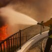 A firefighter makes a stand in front of the advancing Palisades Fire in the Pacific Palisades neighborhood of Los Angeles, Tuesday, Jan. 7, 2025. (AP Photo/Etienne Laurent)