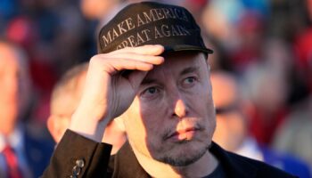 FILE - Tesla and SpaceX CEO Elon Musk listens as Republican presidential nominee former President Donald Trump speaks at a campaign event at the Butler Farm Show, on Oct. 5, 2024, in Butler, Pa. (AP Photo/Alex Brandon, File)