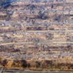 In this aerial view taken from a helicopter, burned homes are seen from above during the Palisades fire in Los Angeles county, California on January 9, 2025. Massive wildfires that engulfed whole neighborhoods and displaced thousands in Los Angeles remained totally uncontained January 9, 2025, authorities said, as US National Guard soldiers readied to hit the streets to help quell disorder. Swaths of the United States' second-largest city lay in ruins, with smoke blanketing the sky and an acrid smell pervading almost every building. (Photo by JOSH EDELSON / AFP)