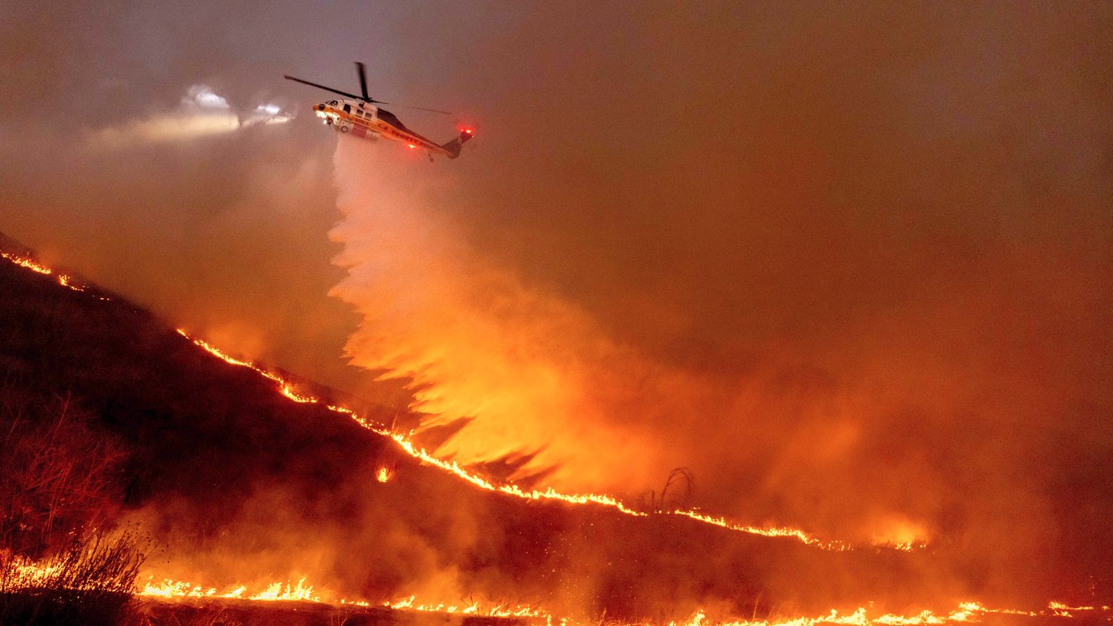 Water is dropped by helicopter on the Kenneth Fire in the West Hills section of Los Angeles, Thursday, Jan. 9, 2025. (AP Photo/Ethan Swope)