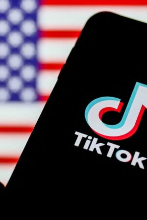 TikTok logo is seen displayed on a phone screen with American flag in the background in this illustration photo taken on August 2, 2020. President of the USA Donald Trump said that Chinese app TikTok will be banned in the United States. (Photo Illustration by Jakub Porzycki/NurPhoto) (Photo by Jakub Porzycki / NurPhoto / NurPhoto via AFP)