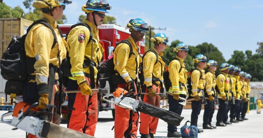 CAMARILLO, CALIFORNIA - JULY 14: Cadets, who were formerly incarcerated, stand with wildland firefighting equipment at the Ventura Training Center (VTC) during an open house demonstration for media and prospective participants on July 14, 2022 in Camarillo, California. The program was developed in 2018 to take formerly incarcerated people, who previously battled fires as California Department of Corrections and Rehabilitation (CDCR) inmate camp members, and train them for a career as professional firefighters. As climate change has stoked increased wildfire behavior in California, there is a surge in demand for trained wildland firefighters across the state. Participants are carefully screened before being accepted to the free 18-month program where they receive a monthly stipend, health insurance, life coaching and mentorship in an effort to reduce recidivism.   Mario Tama/Getty Images/AFP (Photo by MARIO TAMA / GETTY IMAGES NORTH AMERICA / Getty Images via AFP)