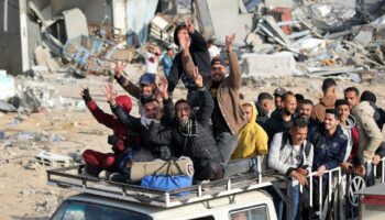 Des déplacés palestiniens font le V de la victoire à leur retour à bord d'une camionnette dans la ville de Rafah dans le sud de la bande de Gaza, le 19 janvier 2025