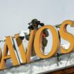 A police officer uses binoculars on a roof, ahead of the annual meeting of the World Economic Forum (WEF) in Davos, Switzerland