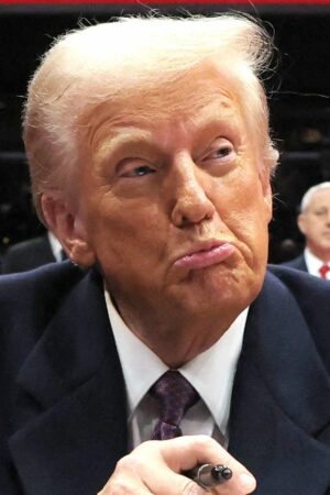 Donald Trump reacts as he signs an executive order during the inaugural parade inside Capital One Arena on the inauguration day of his second presidential term, in Washington, U.S. January 20, 2025. REUTERS/Carlos Barria