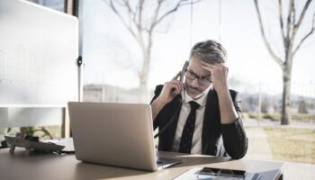 Worried businessman on the phone looking at laptop computer