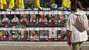 Une femme regarde les portraits d'otages israéliens exposés sur une tente, à Tel-Aviv le 21 janvier 2025