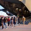 Men in shackles being led on to a military plane. Pic: X/PressSec