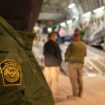 This photo provided by the U.S. Dept. of Defense, A U.S. Customs and Border Protection agent watches as undocumented immigrants are loaded onto a C-17 Globemaster III at Tucson International Airport in Tucson, Ariz., Thursday, Jan. 23, 2025.  (Senior Airman Devlin Bishop/Dept. of Defense via AP)