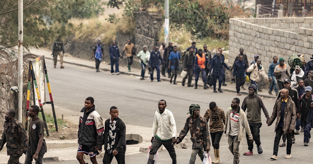 Des membres présumés de l'armée congolaise, des miliciens du Wazalendo (Patriotes en swahili) et d'autres forces congolaises marchent en ligne escortés par des combattants du M23 à Goma, le 28 janvier 2025 en RDC