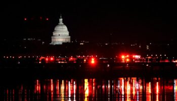 Emergency personnel work near the site of the crash, with the U.S. Capitol in the background, after American Eagle flight 5342 collided with a Black Hawk helicopter while approaching Ronald Reagan Washington National Airport and crashed in the Potomac River, U.S. January 30, 2025. REUTERS/Nathan Howard TPX IMAGES OF THE DAY