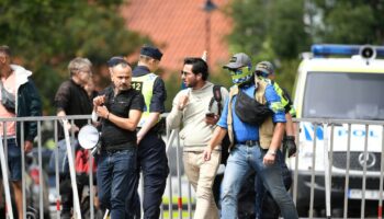 Salwan Momika (C) escorté hors de l'ambassade d'Irak à Stockholm en Suède, le 20 juillet 2023