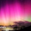 bright pinks in the night sky of the aurora.  Some cloud on the horizon with a green tinge behind the cloud.