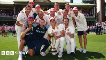 Australia team celebrate beating India with captain Pat Cummins holding the Border-Gavaskar trophy