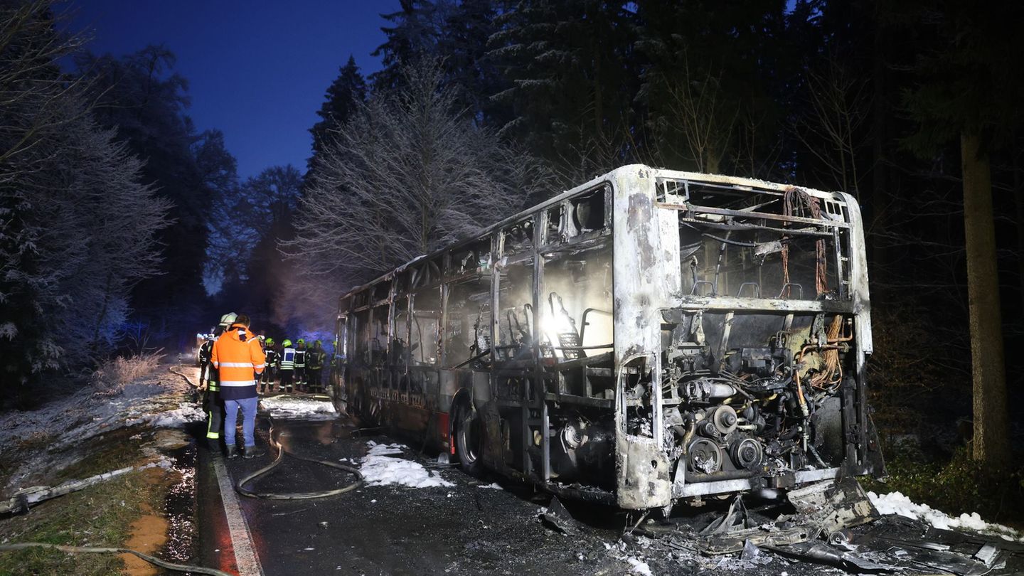 Einsatzkräfte stehen neben einem ausgebrannten Bus. Der Linienbus ist im Kreis Biberach in Brand geraten. Foto: Ralf Zwiebler/dp