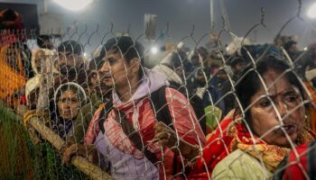 Pilger auf Indiens Pilgerfest Kumbh Mela an einem Zaun