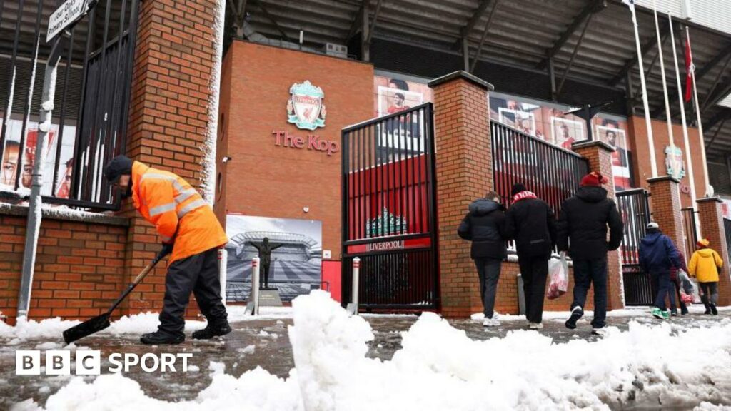 Workers clear snow outside Liverpool's Anfield Stadium