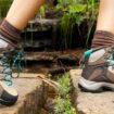 Eine Frau trägt Wanderschuhe und läuft damit im Wald