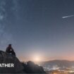 Quadrantid meteor streaks across a night sky. Silouette of of trees and hills in the foreground.