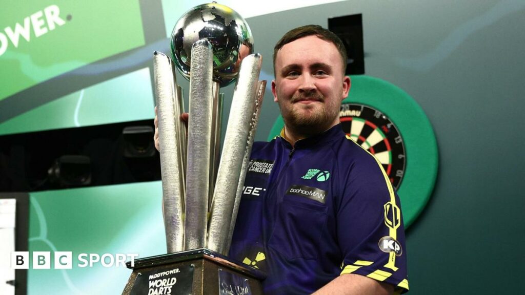 Luke Littler lifts the PDC World Darts Championship trophy at Alexandra Palace