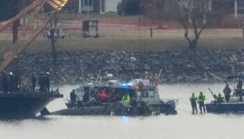 A Coast Guard vessel with a crane is pictured as it works near the wreckage of a Black Hawk helicopter in the Potomac River. Pic: AP Photo/Alex Brandon