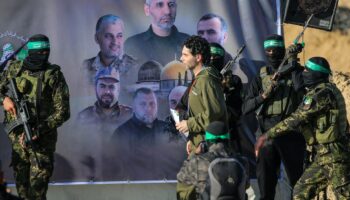 Des combattants du Hamas escortent l'otage franco-israélien Ofer Kalderon sur une scène avant de le remettre à une équipe de la Croix-Rouge à Khan Yunis, le 1er février 2025, dans le cadre d'un quatrième échange d'otages et de prisonniers. (Photo Eyad BABA / AFP)