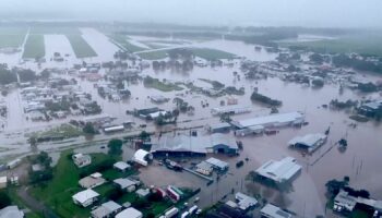 Woman dies and thousands urged to move to higher ground as 'record-breaking rainfall' hits Queensland