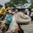 A man displaced by the fighting evacuates with his belongings to downtown Goma. Pic: AP