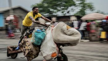 A man displaced by the fighting evacuates with his belongings to downtown Goma. Pic: AP