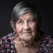 Holocaust Survivor of the concentration and extermination camp of Auschwitz-Birkenau Ginette Kolinka poses during a photo session, in Paris, on April 15, 2022. (Photo by JOEL SAGET / AFP)