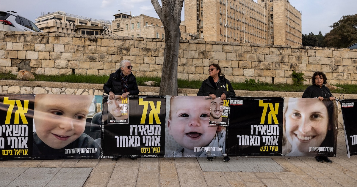 Des proches d'otages israéliens à Gaza tiennent des photos d'une mère et de ses deux enfants encore captifs, lors d'une manifestation devant le bureau du Premier ministre à Jérusalem, le 3 février 2025