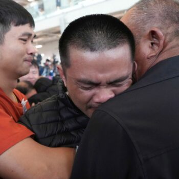 Former hostage Pongsak Thaenna, centre, hugs a relative at Suvarnabhumi Airport. Pic: AP