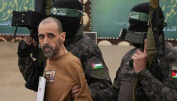 Israeli captive Eli Sharabi, is escorted by Hamas fighters before being handed over to the Red Cross. Pic: AP