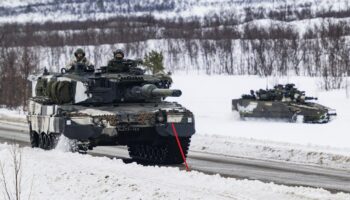 Finnish soldiers of the Finnish-Swedish Division ride the Leopard 2A6, a third generation German main battle tank, during a demonstration of border crossing by Swedish and Finnish troops as part of the NATO Nordic Response 24 military exercise on March 9, 2024 on the Norwegian side of the Kivilompolo border crossing between Finland and Norway, located above the Arctic Circle. Nordic Response 24 is part of the larger NATO exercise Steadfast Defender. The exercise involves air, sea, and land forces, with over 100 fighter jets, 50 ships, and over 20,000 troops practicing defensive manoeuvres in cold and harsh weather conditions. (Photo by Jonathan NACKSTRAND / AFP)