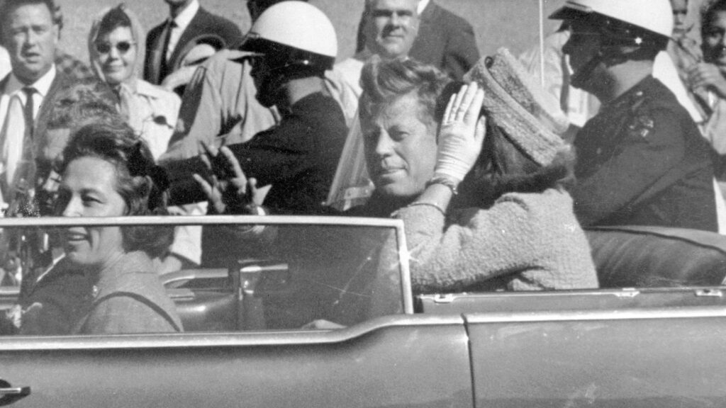 JFK waves from car in a motorcade in Dallas shortly before being killed. Pic: AP/Jim Altgens