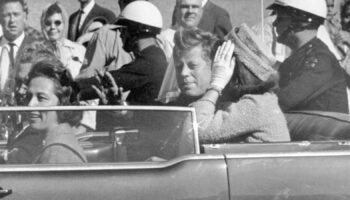 JFK waves from car in a motorcade in Dallas shortly before being killed. Pic: AP/Jim Altgens